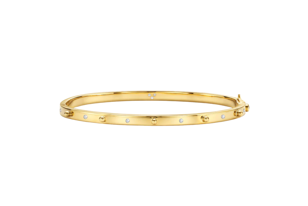 A yellow gold bangle with diamond accents.