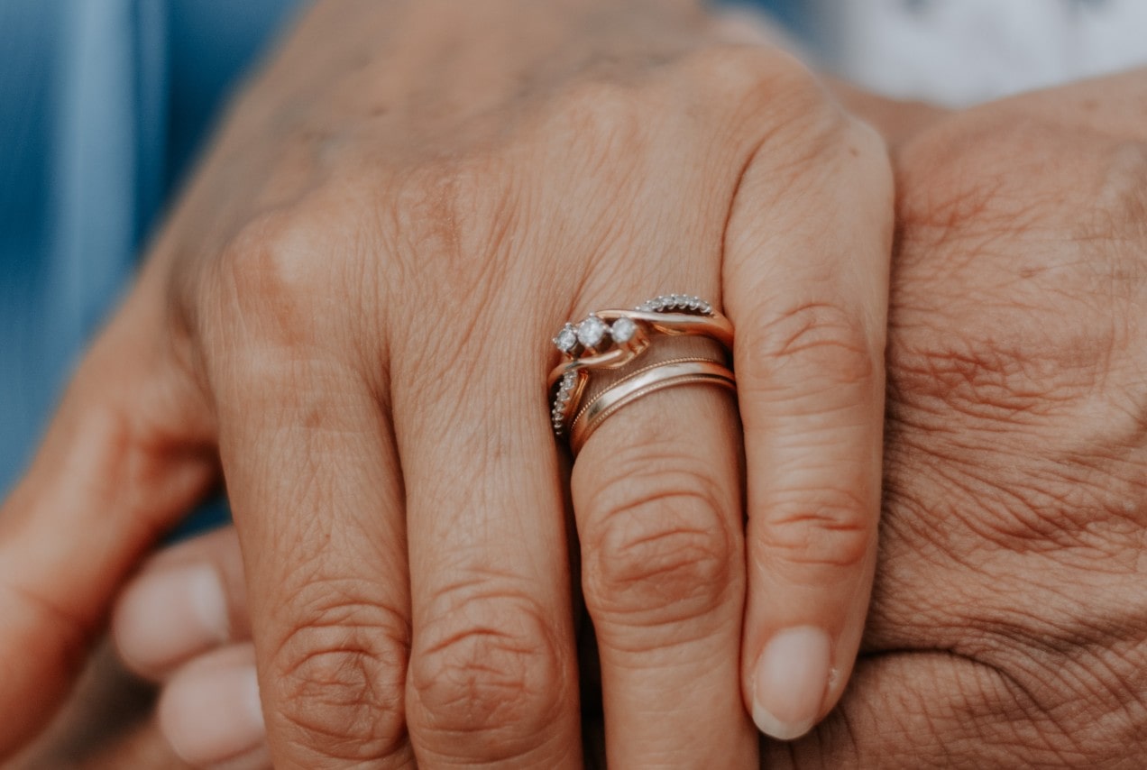 A rose gold bridal set: polished wedding bands and intertwined diamond engagement ring.