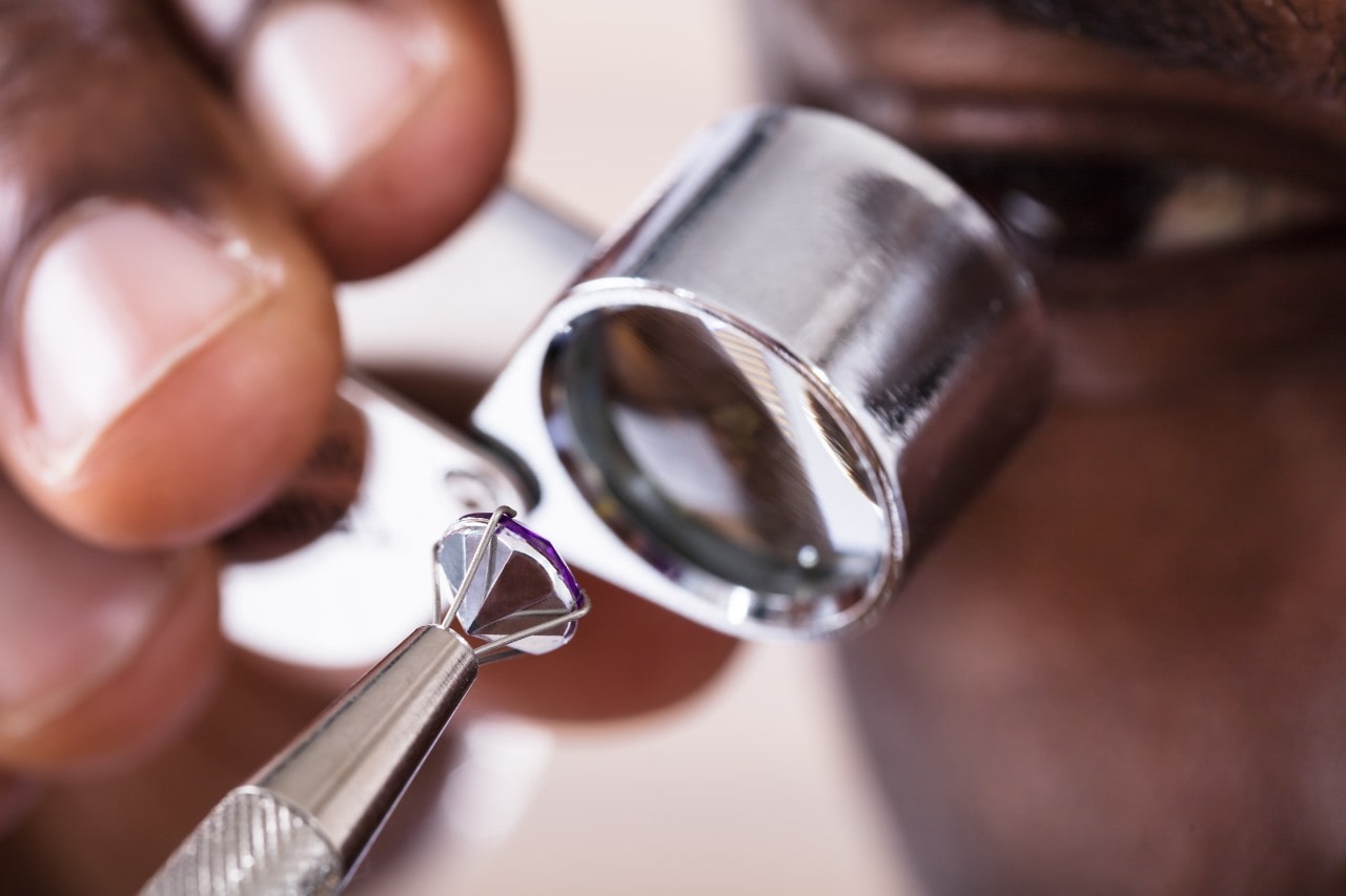 A jeweler inspects a loose diamond through a loupe for clarity and precision.