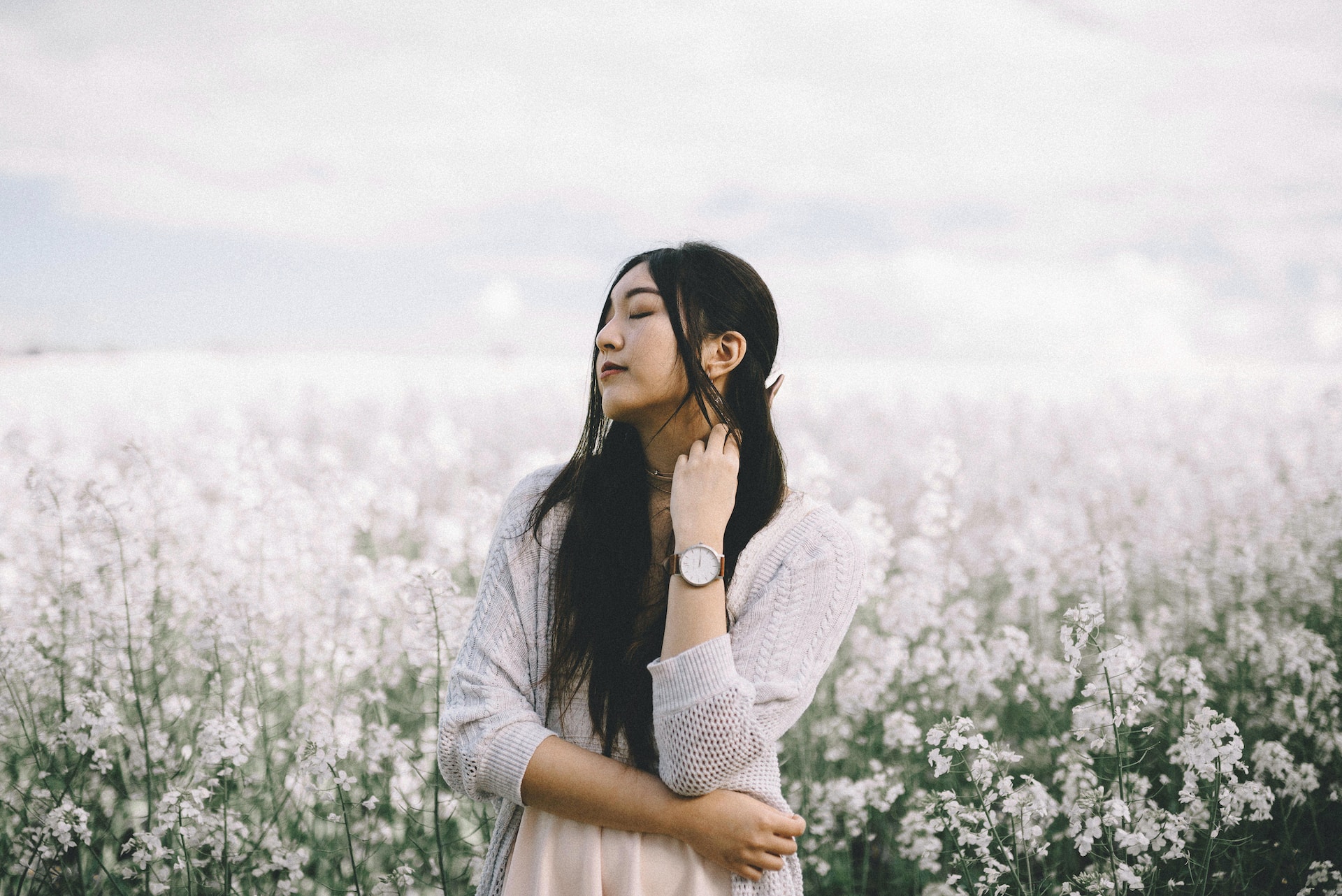 lady wearing a luxury timepiece with eyes closed standing out in nature