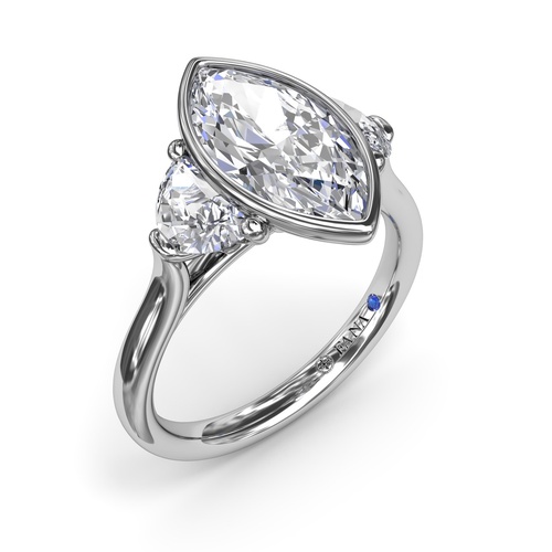 A white gold three-stone engagement ring with a marquise-cut bezel-set diamond centerpiece.