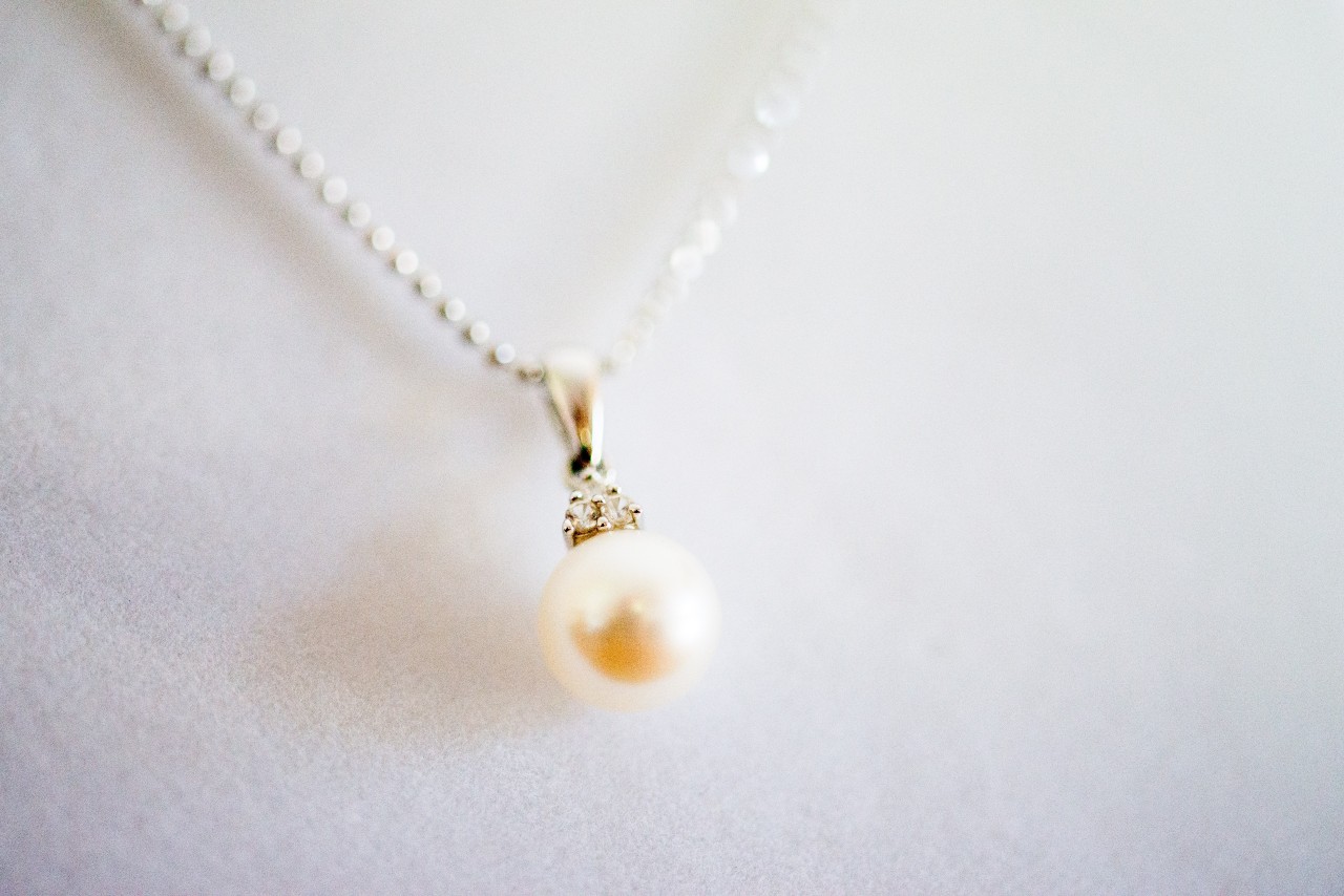 A pearl pendant necklace against a white background.