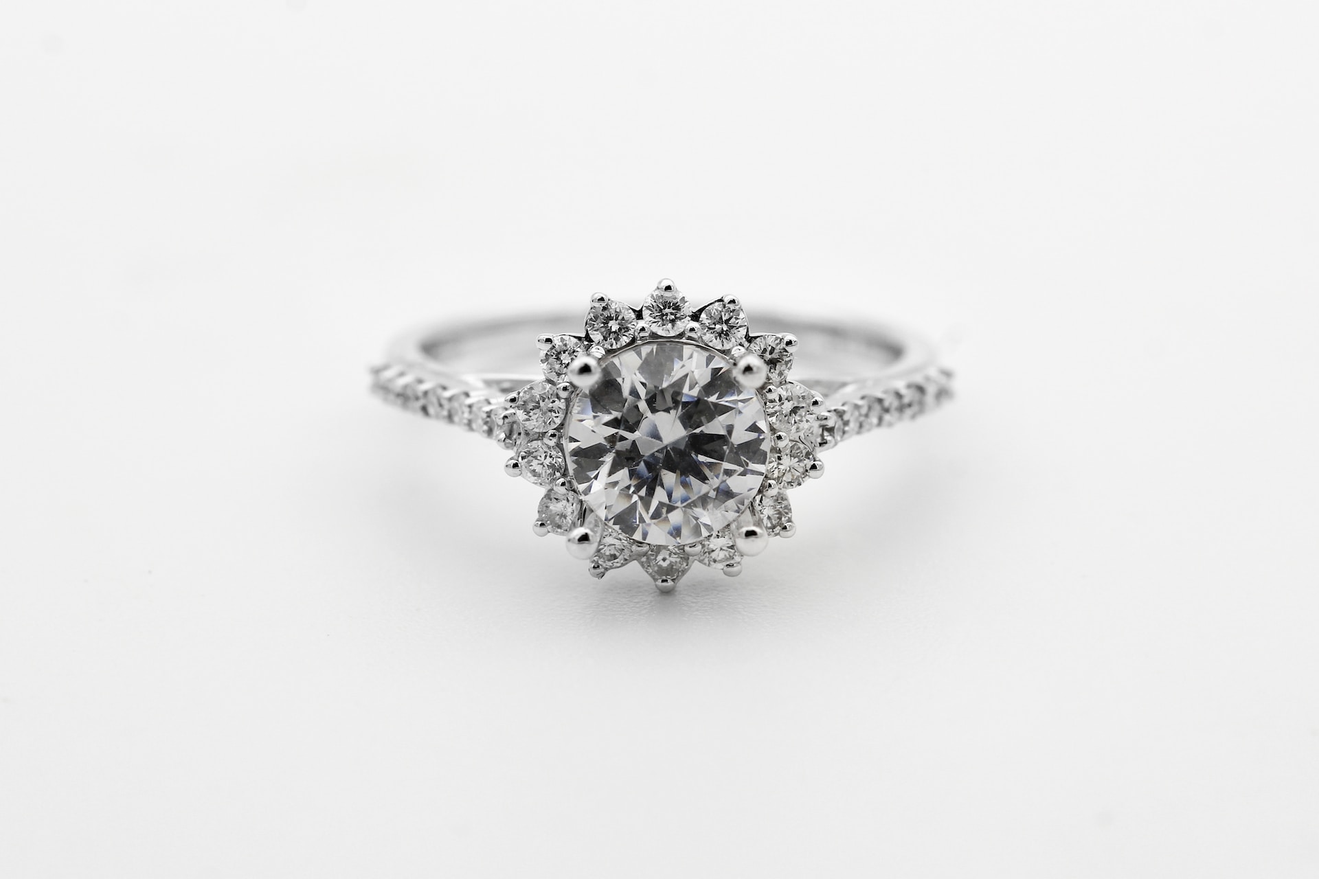 a white gold engagement ring with a halo set, round cut center stone