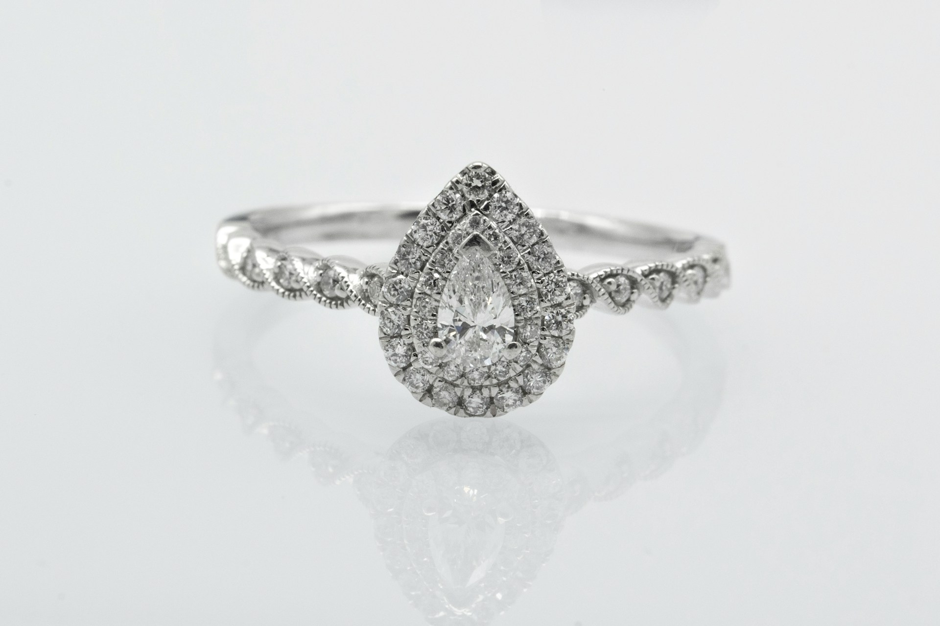 a pear shape, double halo engagement ring with side stones