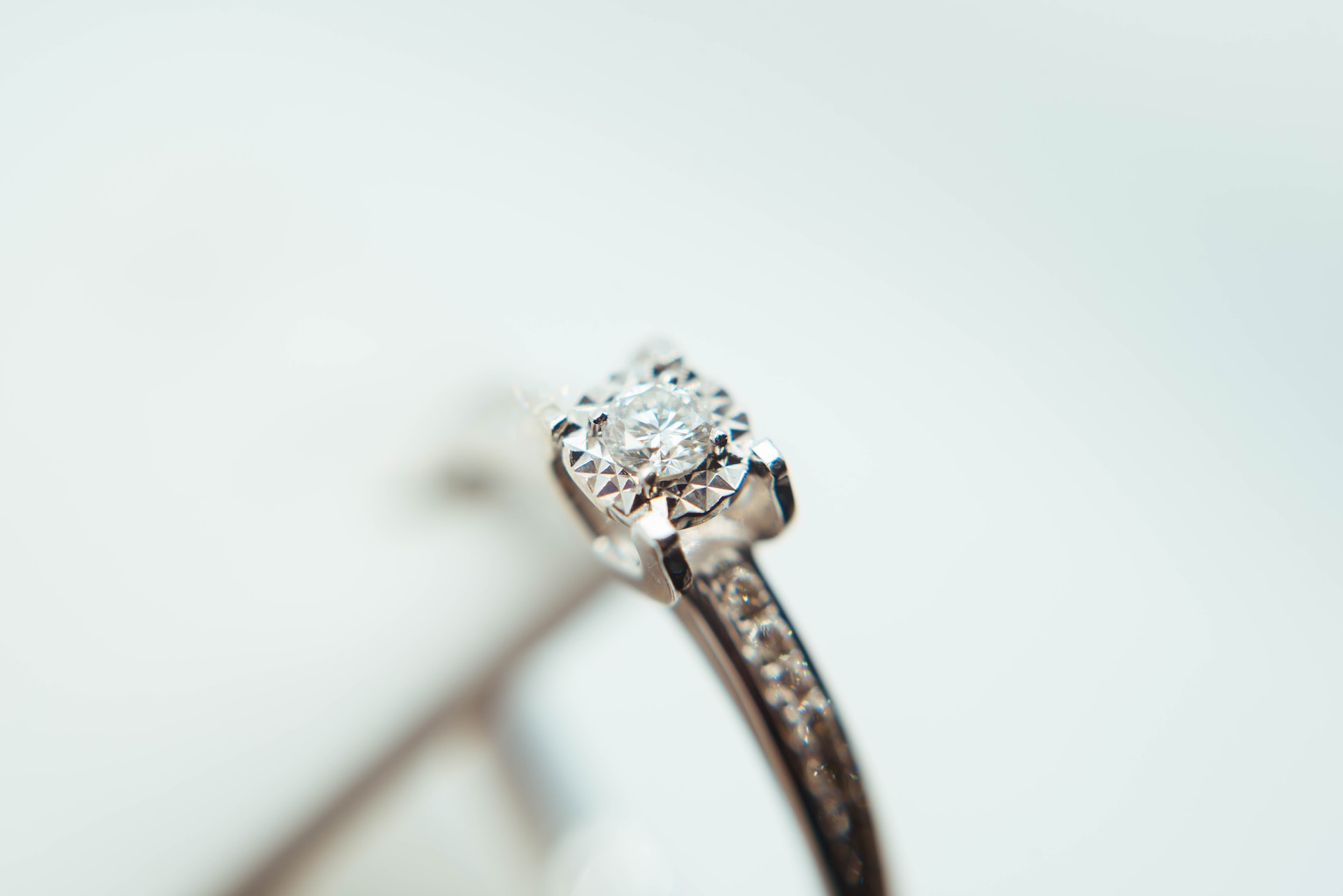 close up image of an engagement ring with a round cut center stone and channel set side stones