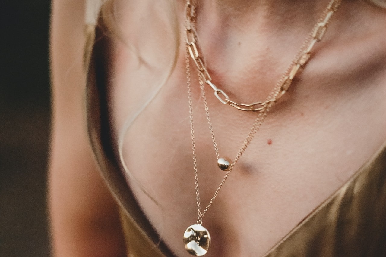 A yellow gold blue topaz pendant with blue topaz and white diamond halos