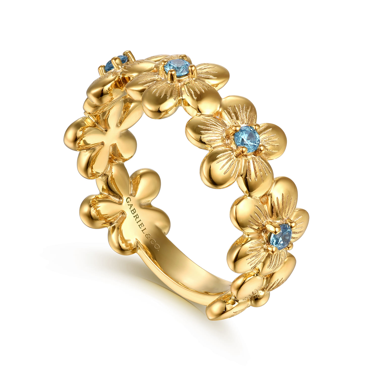 A yellow gold ring with floral design and blue gemstone centers